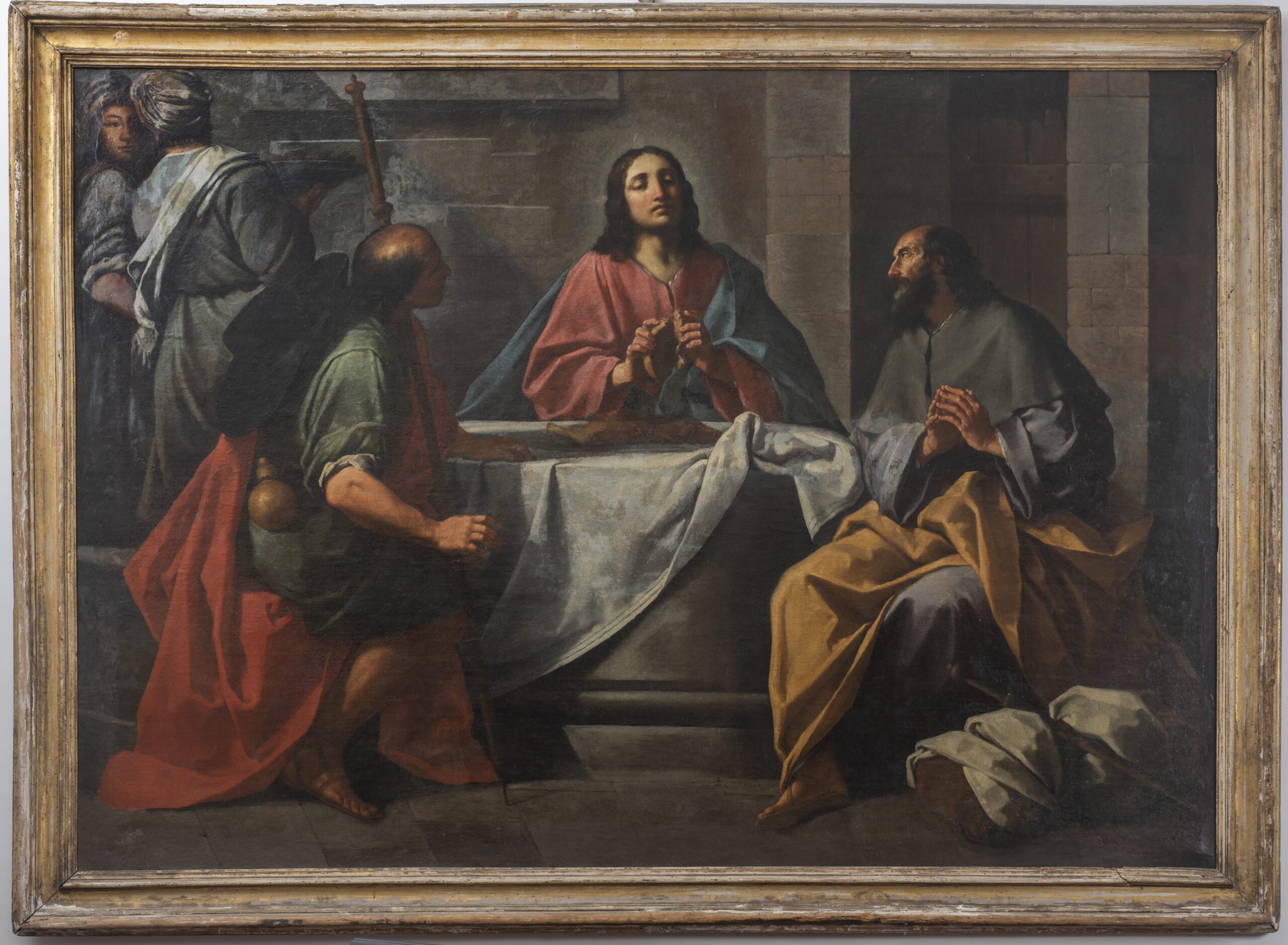 Maestro caravaggesco attivo alla metà del XVII secolo.       
Cena in Emmaus
Olio su tela
1650 circa
cm. 150 x 218


La Cena in Emmaus del San Michele è un capolavoro del quale non sono conservati documenti che consentano di arrivare ad una attribuzione precisa. 
I chiaroscuri sono molto evidenti grazie a una luce che proviene da sinistra, segno di una suggestione che l’autore ha tratto dal Caravaggio. I colori caldi e chiari, assieme a una combinazione simmetrica delle figure nello spazio, riconducono a un ambiente nord-italiano, probabilmente veneto. Ciò è sufficiente a datare il dipinto alla metà del Seicento. Il soggetto è raffigurato in modo essenziale: Cristo appare a due discepoli nelle vesti di un mendicante invitato a tavola e viene riconosciuto nel momento in cui, benedicendo il pane e il vino, compie il sacramento dell’Eucaristia. 