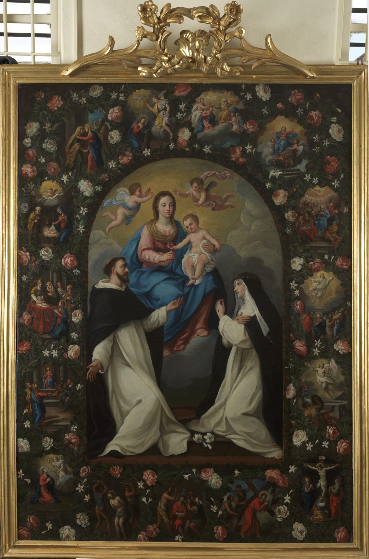 Maestro romano attivo nella prima metà del XVIII secolo Madonna col Bambino tra S. Domenico, S. Caterina e i quindici misteri del Rosario 1730 circa olio su tela cm 200X152 La grande pala d’altare si trovava in origine nella chiesa di S. Maria della Trasfigurazione all’interno dell’antico Ospizio Apostolico del San Michele a Porta Portese. Trasferita assieme a tutte le altre opere presenti in mostra nella nuova sede dell’Istituto a Tor Marancia rappresenta oggi uno dei pezzi più interessanti della collezione. Il soggetto è legato alla devozione per Maria Vergine e alla preghiera del Rosario, due aspetti molto sentiti nella devozione popolare romana. Al centro la Madonna e il Bambino tengono insieme una rosa, simbolo di purezza e di assenza del peccato originale; sotto di loro San Domenico e Santa Caterina accolgono il fiore che la Vergine e il Bambino porgono dall’alto. Attorno alle figure, come una cornice, si snodano gli episodi del Rosario rituale che vanno letti partendo dalla scena dell’Annunciazione, in alto, e scendendo verso sinistra in senso antiorario: si riconoscono la Visitazione, la Nascita di Gesù, la Presentazione al Tempio, Gesù tra i Dottori, Gesù nell’orto degli Ulivi, la Flagellazione, la Corona di Spine, Gesù al Calvario, La Crocifissione, la Resurrezione, l’Ascensione, la Discesa dello Spirito Santo nel Cenacolo, l’Assunzione di Maria in Cielo, l’Incoronazione della Vergine. Opera di un maestro del Settecento romano probabilmente attivo nella bottega di Marco Benefial, grazie al restauro la pala sta ritrovando i colori brillanti tipici del tardo Barocco Romano. (Tommaso Strinati)